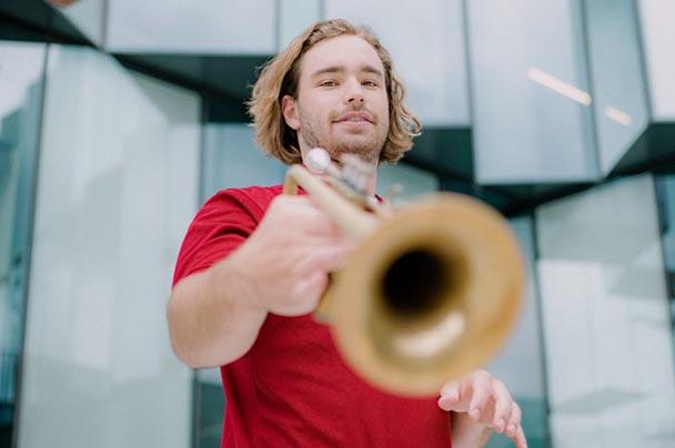 A student poses with his trumpet